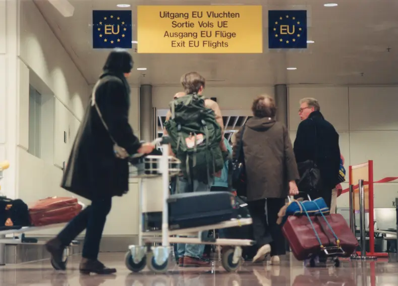 Voyageurs dans un aéroport se dirigeant vers la sortie réservée aux vols intra-européens