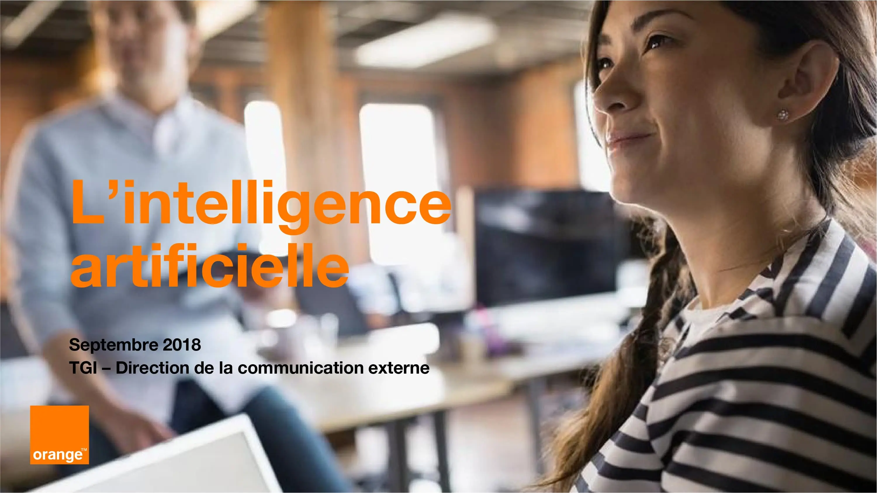 Présentation Orange sur l'intelligence artificielle, septembre 2018, TGI / Direction de la communication externe. Femme en tenue rayée dans un bureau moderne lumineux
