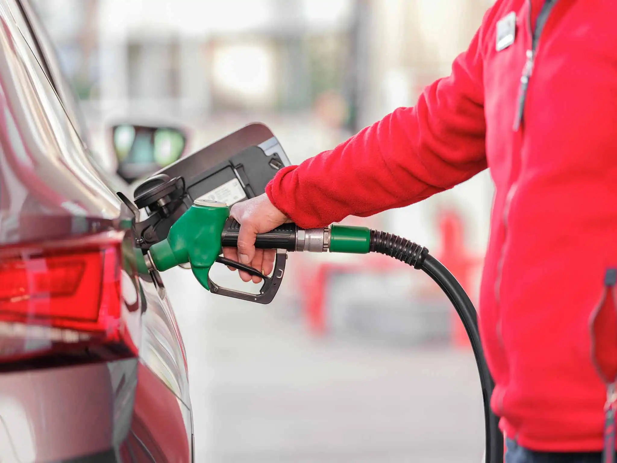 Une personne faisant le plein de sa voiture à une station essence