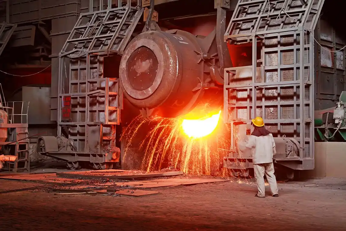 Coulée de métail en fusion à la base d'un haut-fourneau